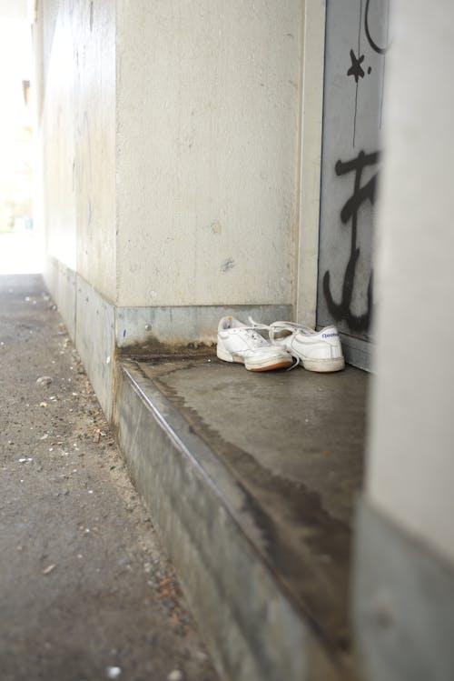 Photo of White Sneakers on a Doorstep