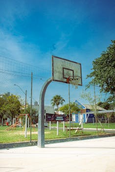 A vibrant outdoor basketball court with a clear blue sky, perfect for summer sports activities.