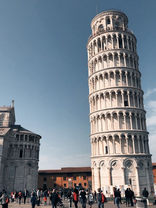 Free The famous Leaning Tower of Pisa with tourists on a clear day in Tuscany, Italy. Stock Photo