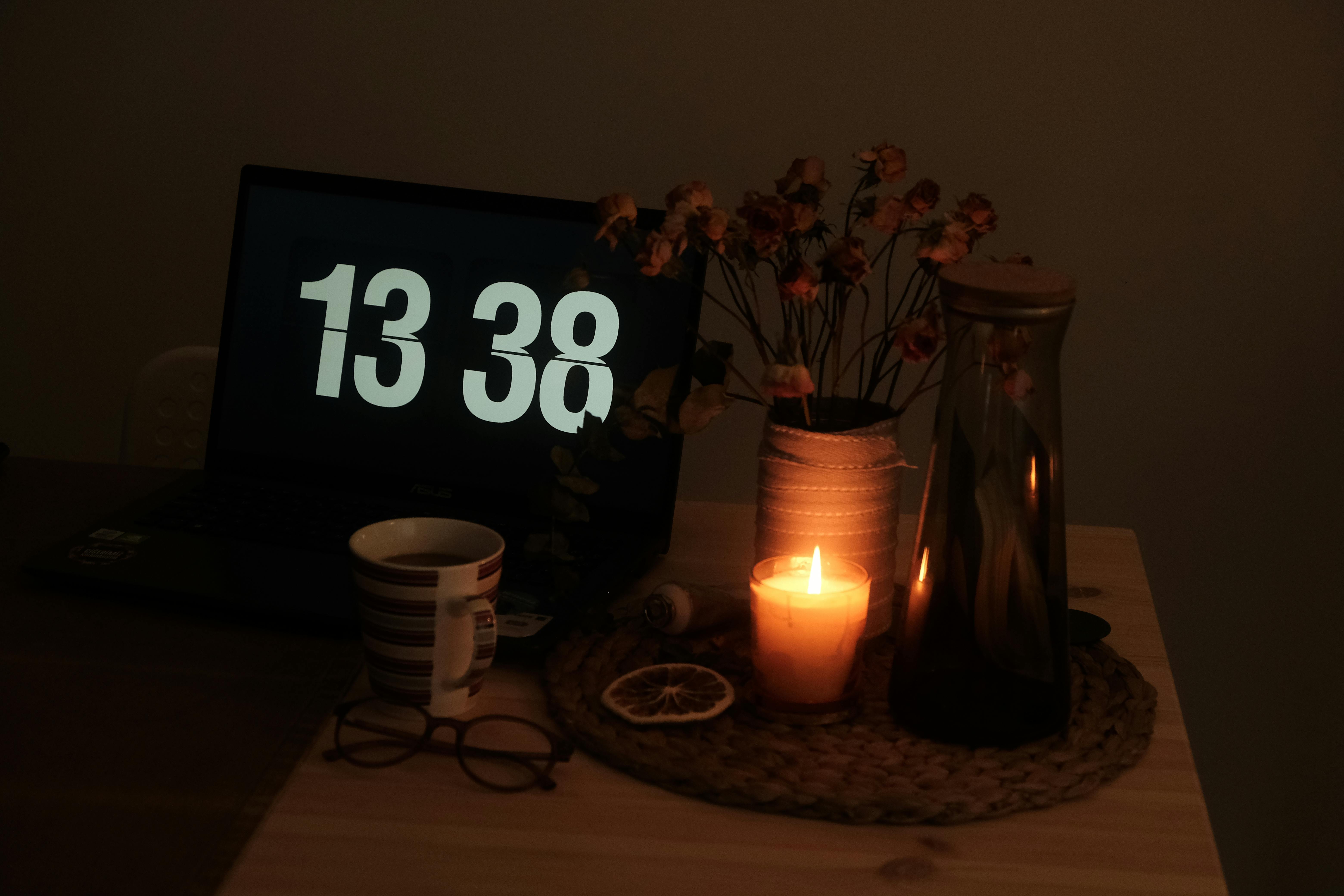 A cozy, dimly lit room with a laptop, a mug of tea, and a blanket. The vibe is 