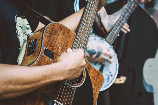 Close-up of musicians strumming acoustic and banjo guitars in a vibrant street performance.