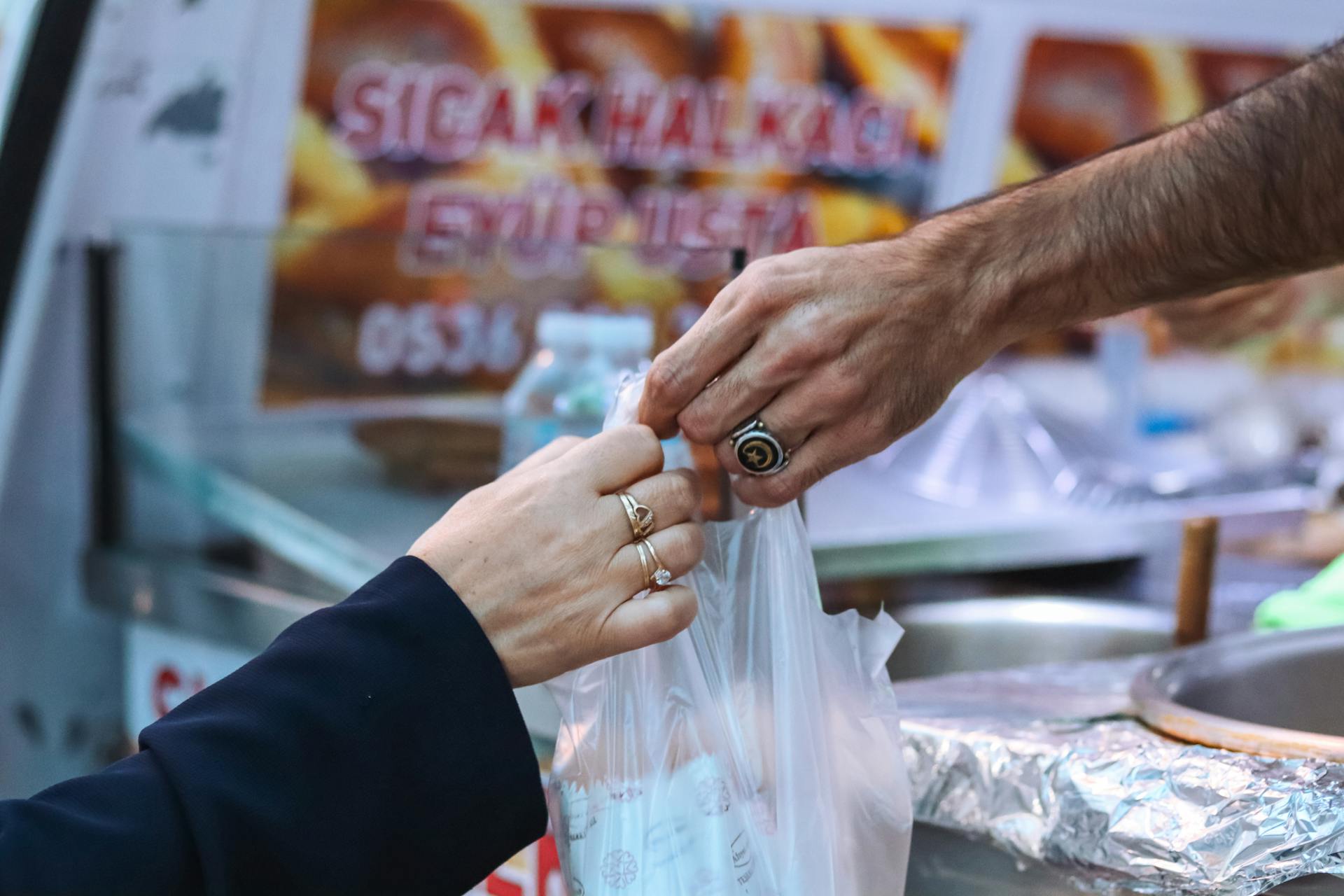 Hands exchanging goods in a market, depicting a local shopping experience.