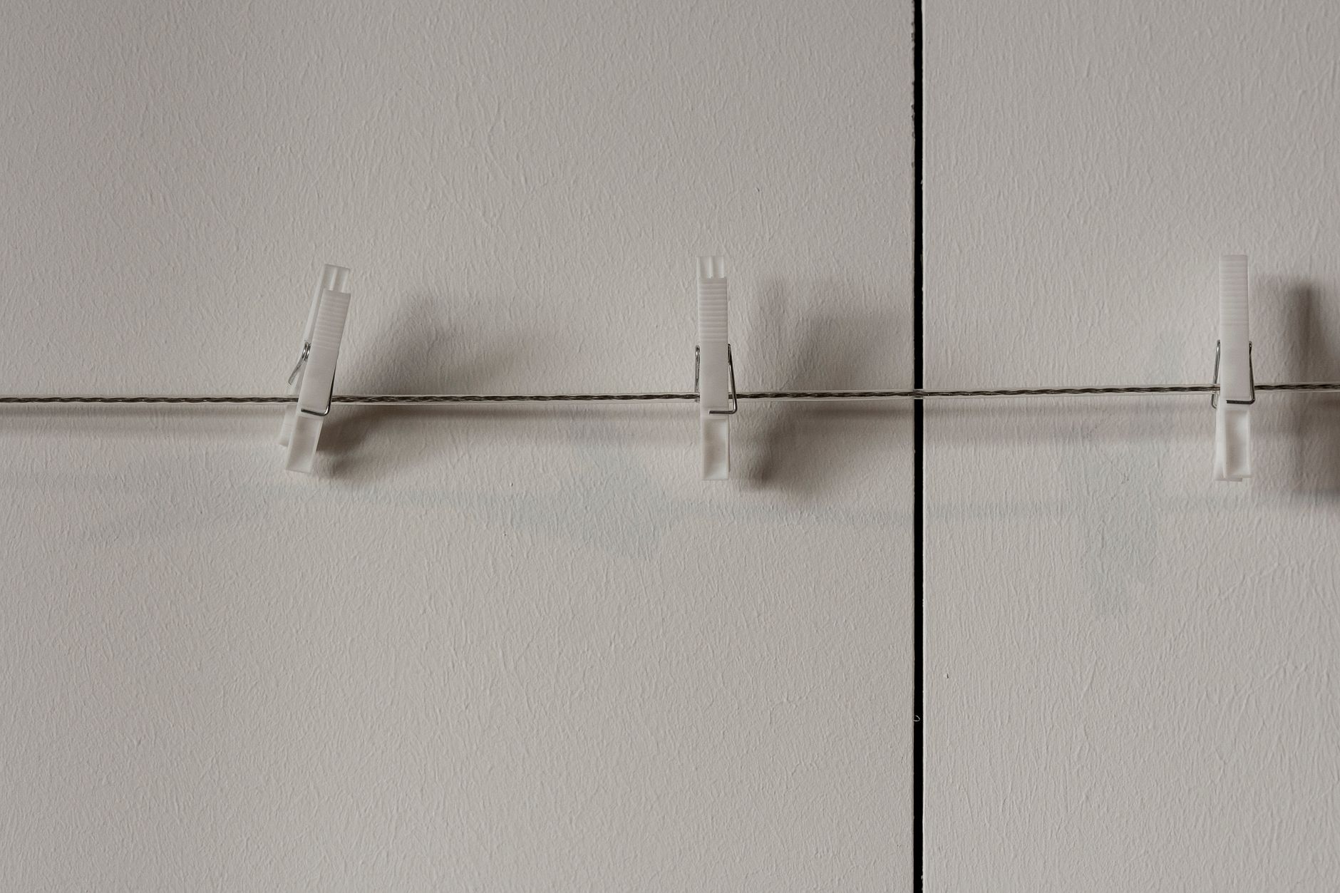 Damage Free Wall Solutions from Home Depot Minimalist image of a string with white clips against a pale wall