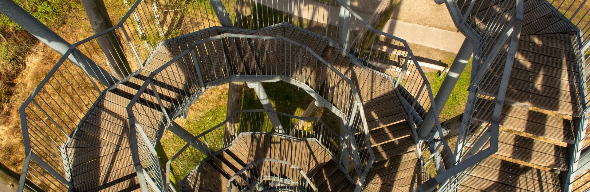 Captivating top view of a spiral metal staircase in a serene forest setting.