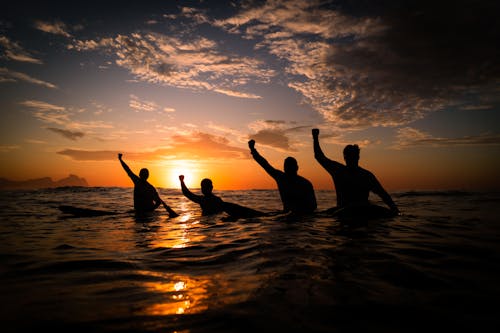 Silhouette of People Playing in the Sea at Dusk