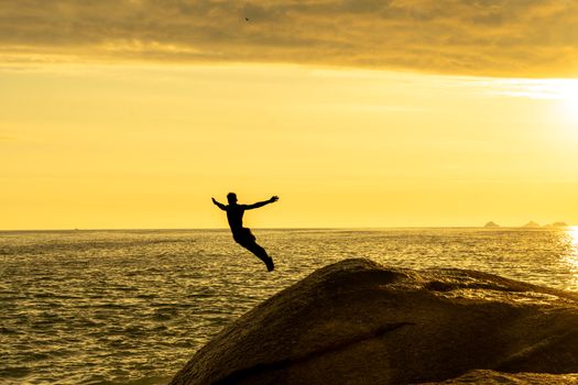 Man Jumping to Sea at Golden Hour