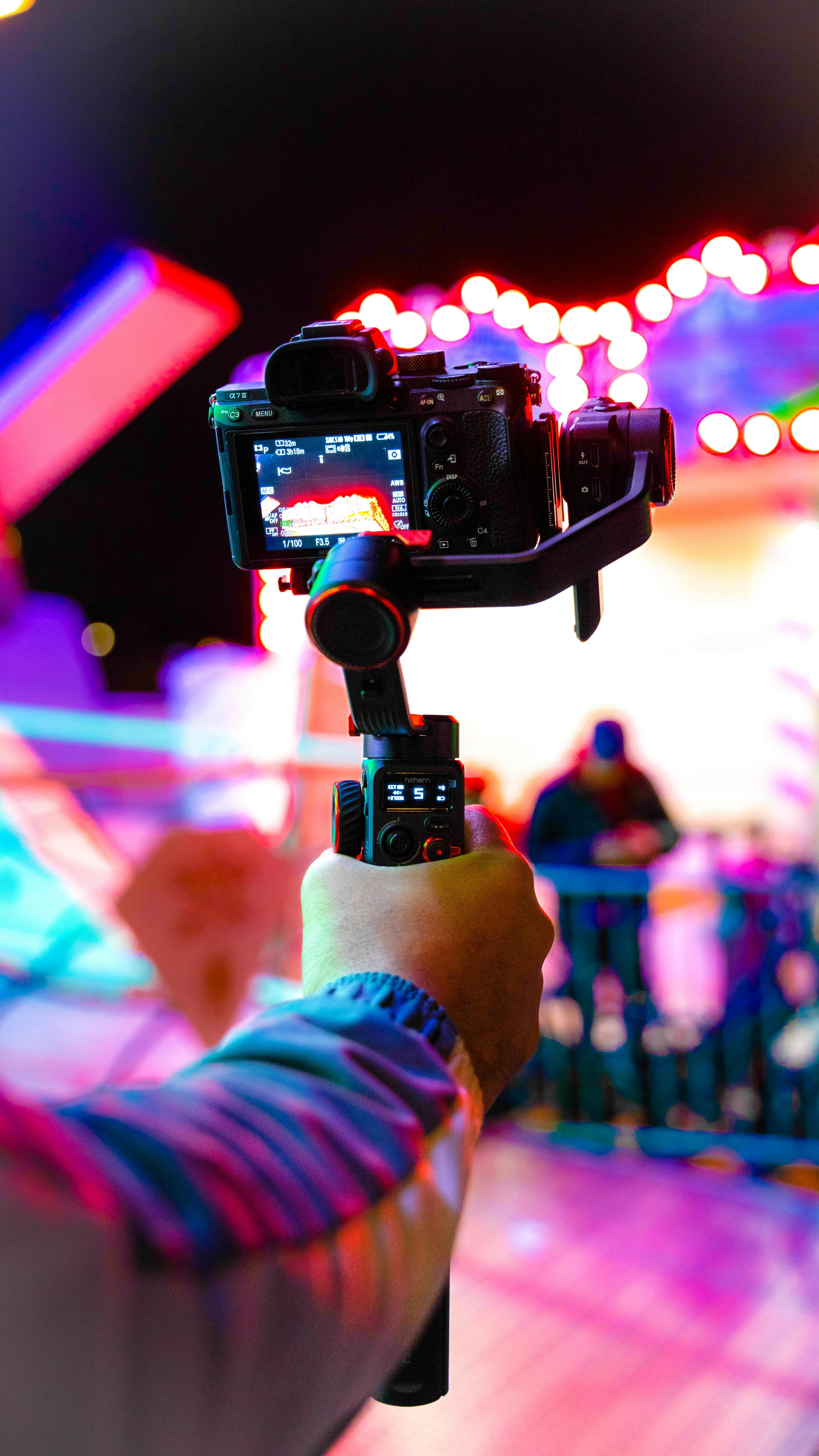 man holding a camera and electric lights