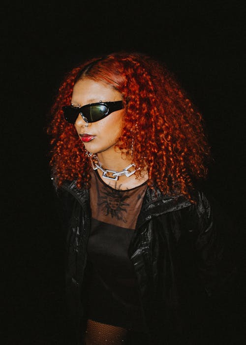 Redhead Model Posing in Sunglasses against Black Background