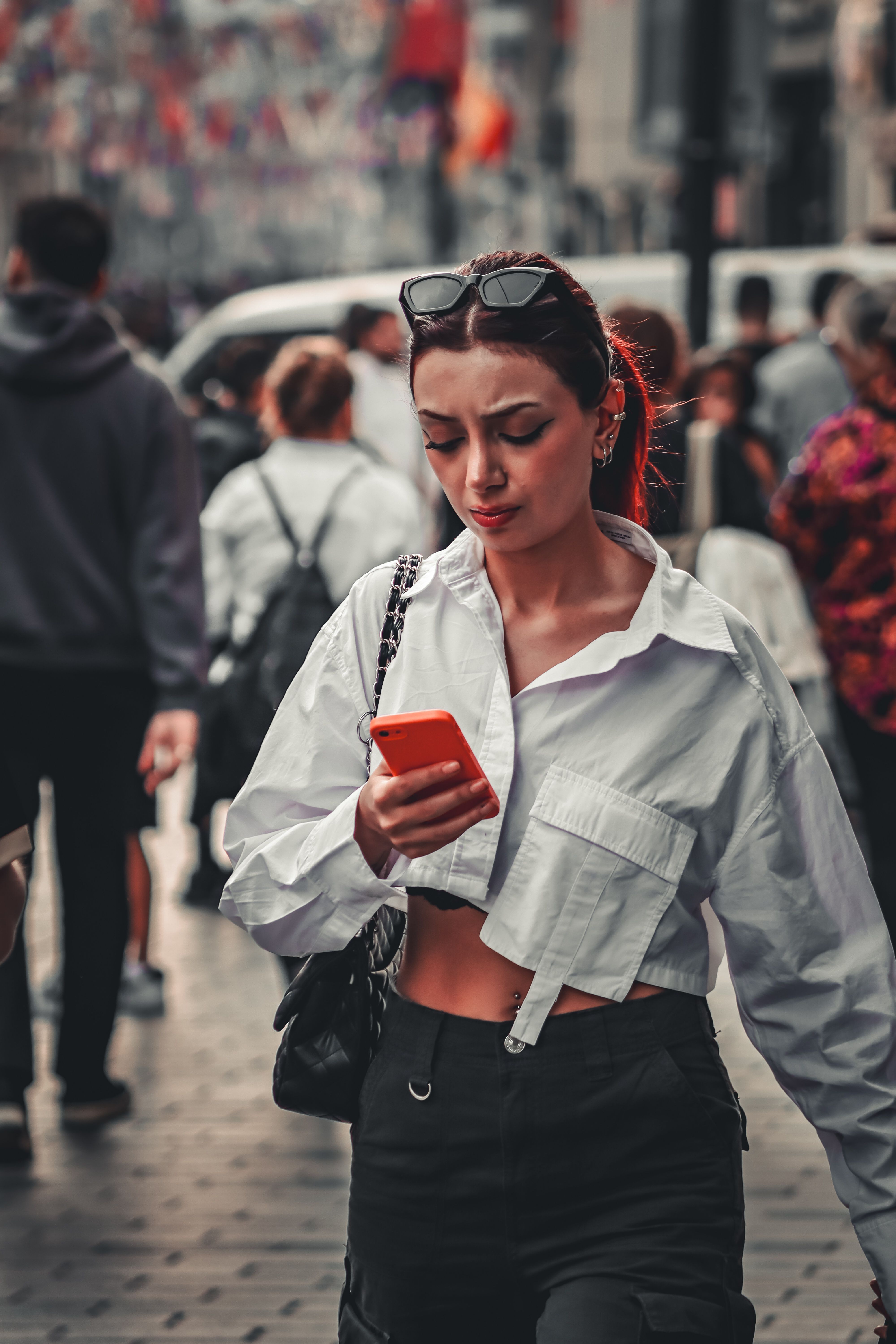 Telefonuna bakarak yürüyen bir kadın