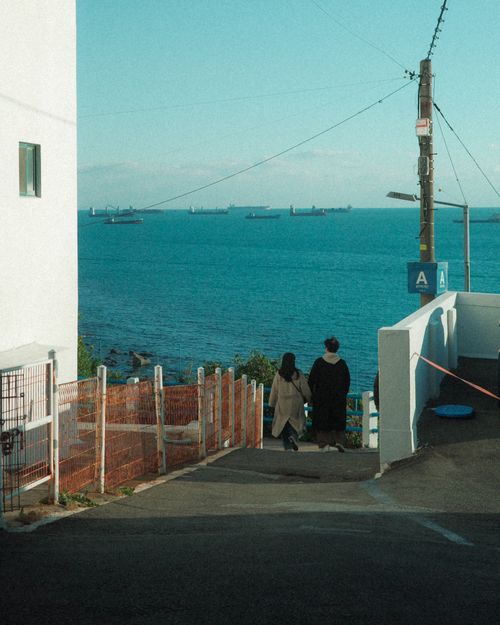 Free Peaceful scene of a couple enjoying the coastal street view in Busan, South Korea. Stock Photo