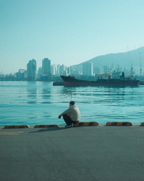 Man Sitting on the Embankment of a Port in Busan 