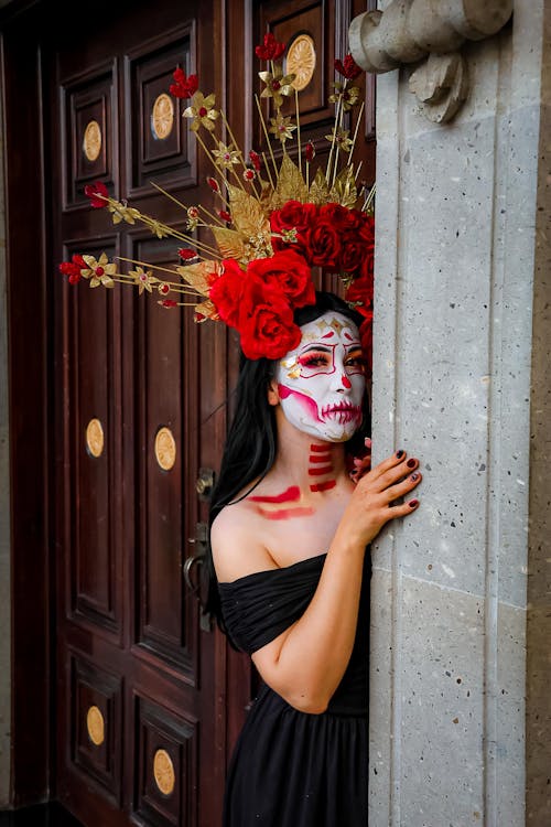 Woman Dressed in a Headpiece for the Day of the Dead Standing by a Stone Column