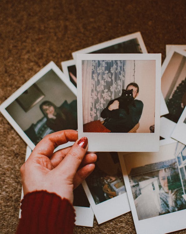 Foto Orang Yang Memegang Polaroid
