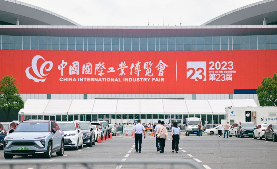Entrance to China International Industry Fair 2023 in Shanghai, featuring people and cars.
