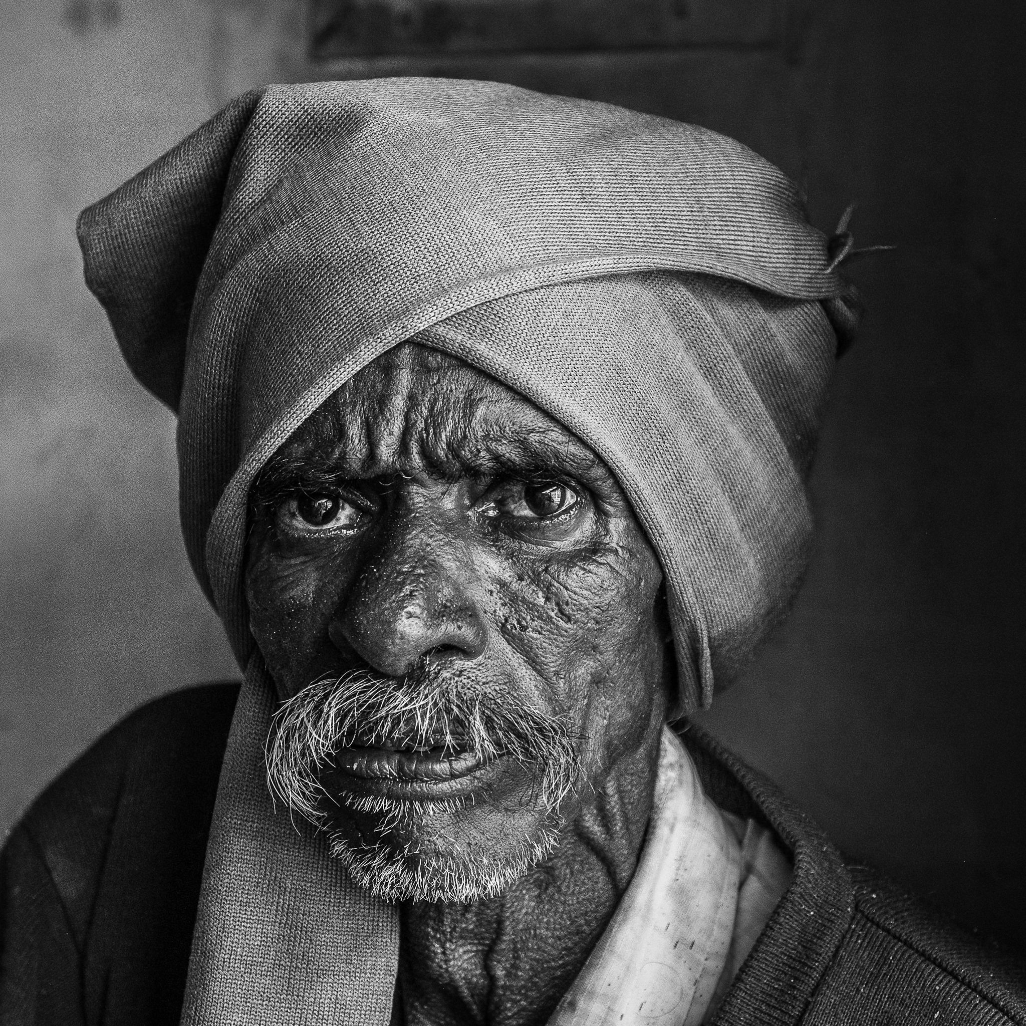 Black and white portrait of an elderly man in India wearing a traditional turban.
