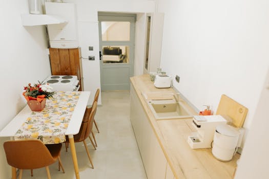 Elegant minimalist kitchen with wood countertops, modern appliances, and dining area.