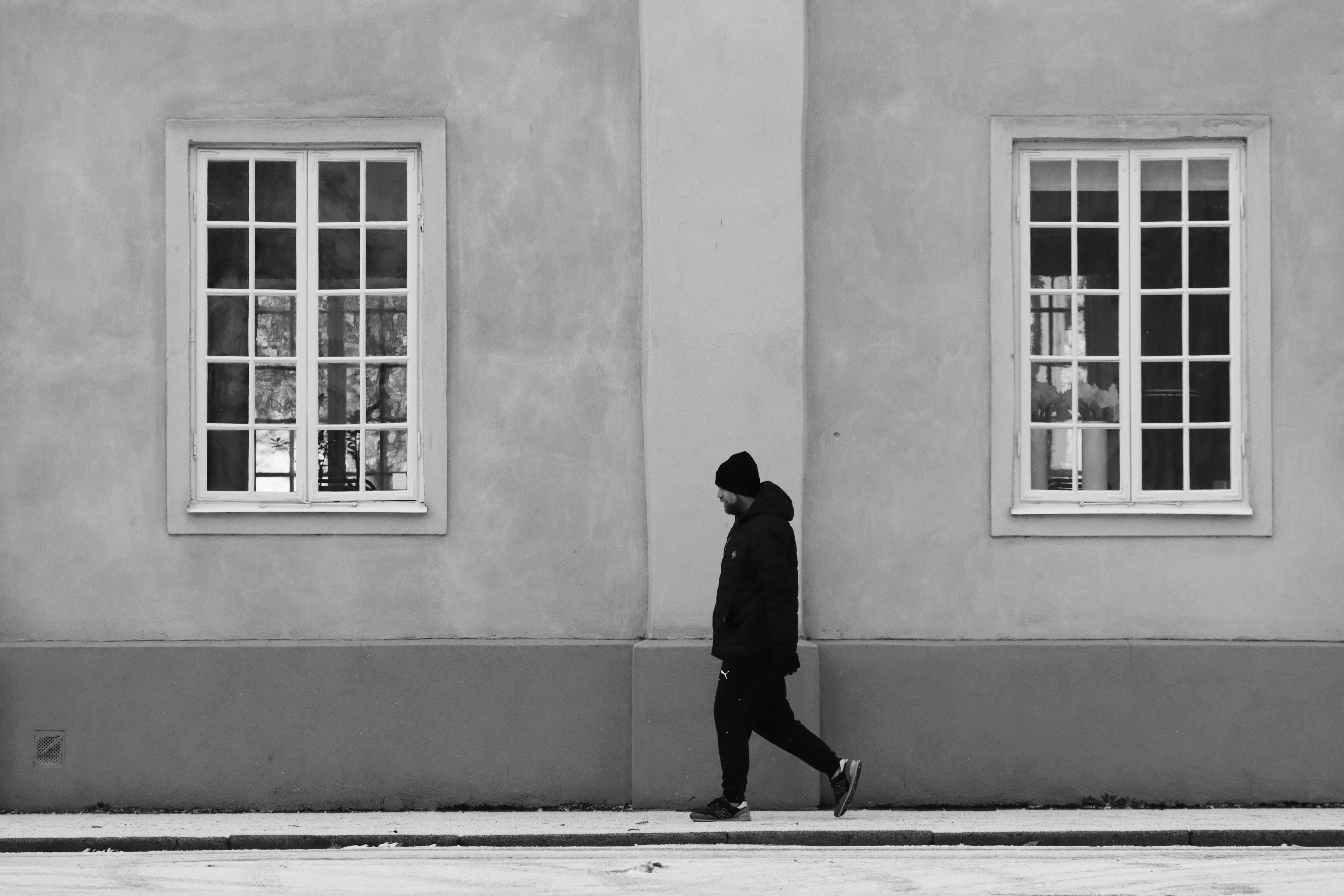 Man Walking near Building Wall in Winter · Free Stock Photo