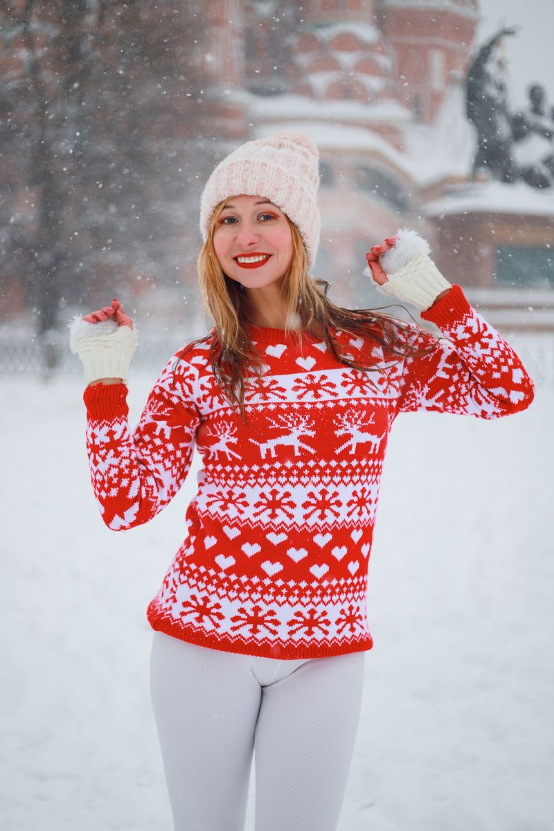 Woman in a red Christmas sweater in the snow