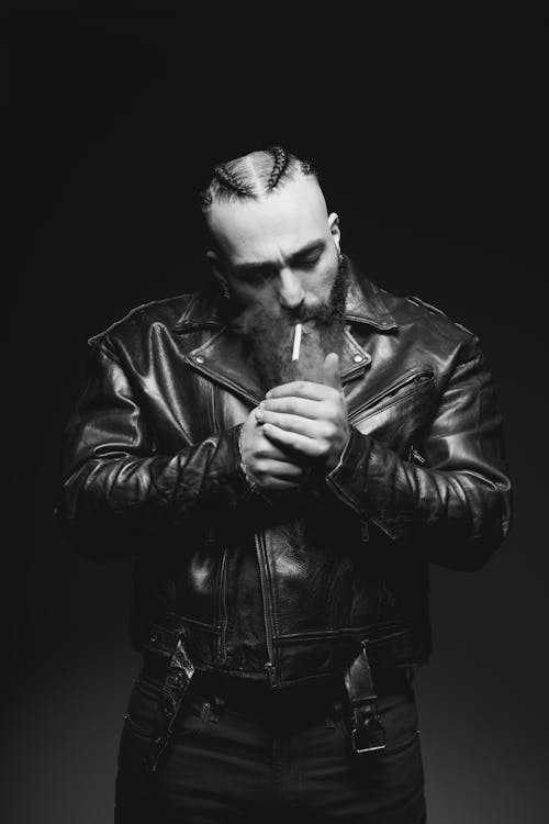 Man in Leather Jacket Lighting Cigarette