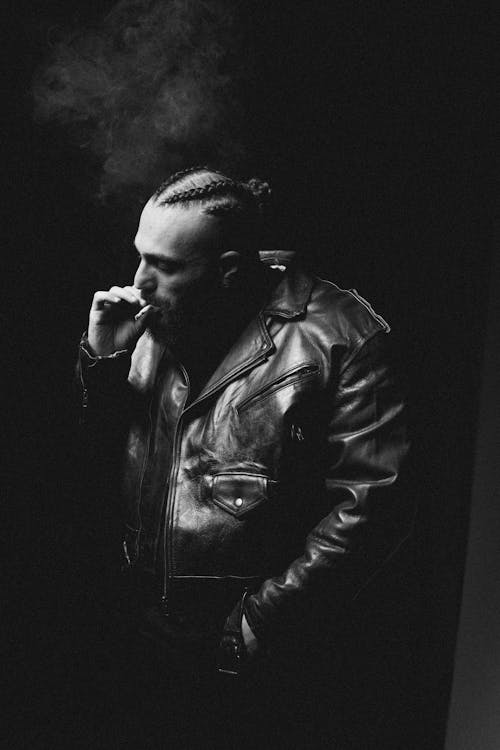 Man Wearing Leather Jacket Smoking a Cigarette in Black and White 