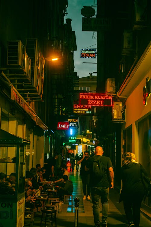 People Walking on Night City Street with Signs