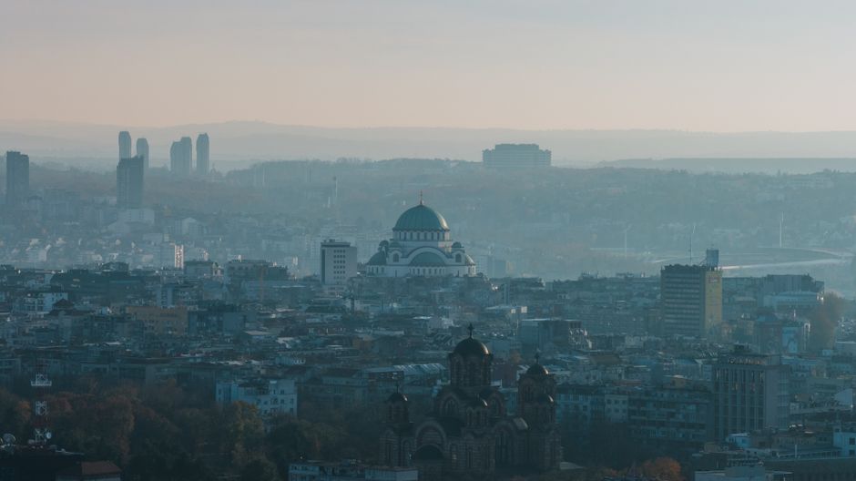 Dramatic aerial cityscape of Belgrade featuring the iconic Saint Sava Cathedral.