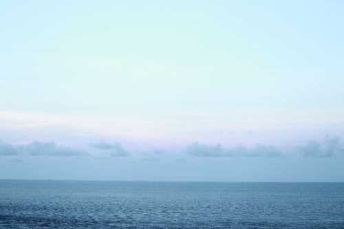 Free Calm ocean scene at dusk with pastel sky, showcasing tranquil nature beauty. Stock Photo
