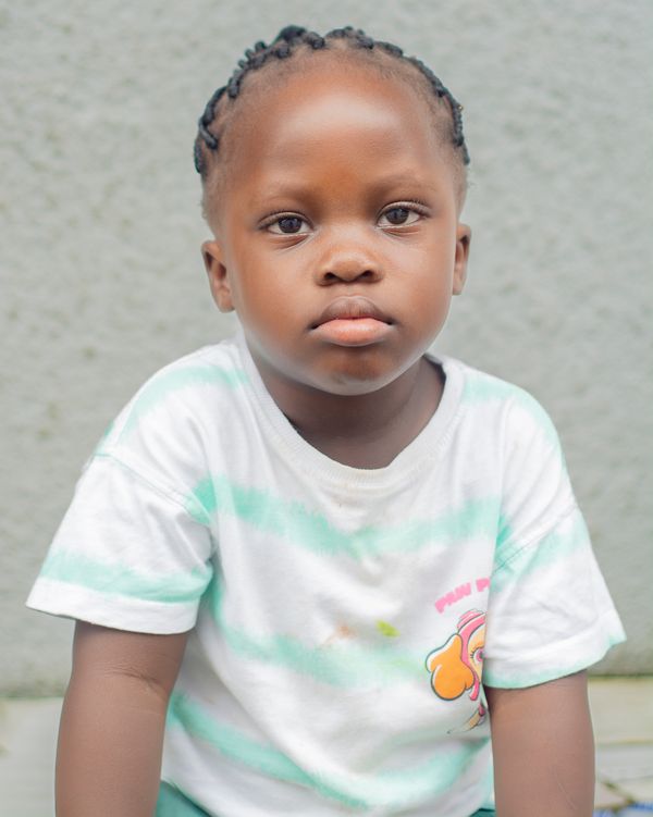 A young child with braided hair wearing a striped shirt