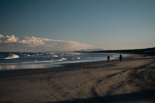 Peaceful beach scene at Marina Romea, Italy with waves and clear skies at sunset.