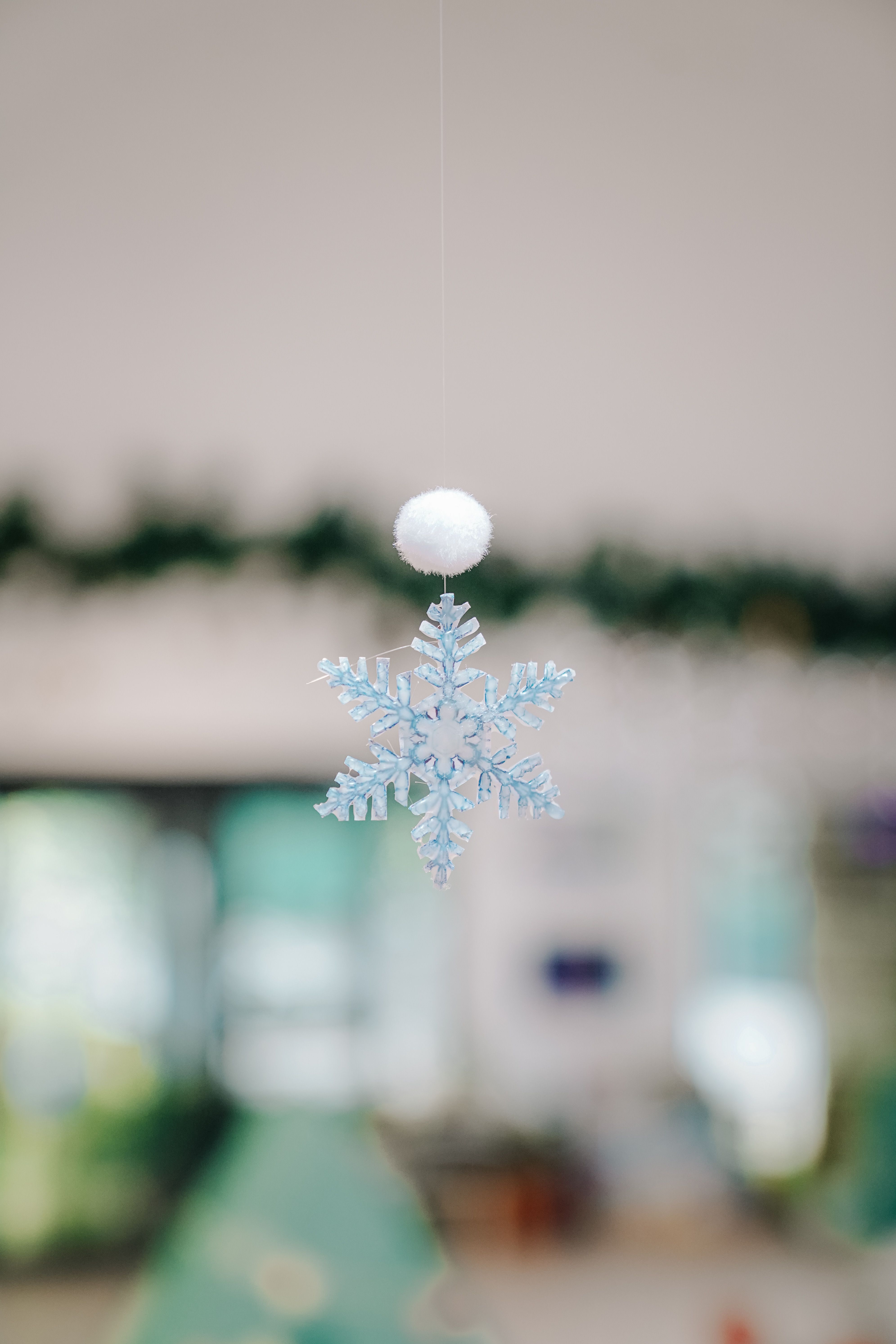 Delicate snowflake ornament hanging indoors, capturing festive Christmas spirit