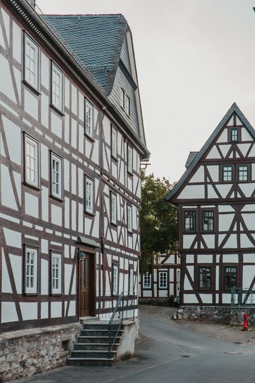 Free Historic half-timbered houses lining a cobblestone street in a picturesque European town. Stock Photo