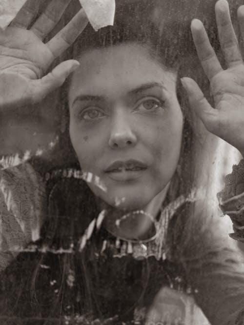Portrait of a Young Woman Leaning behind a Glass Pane