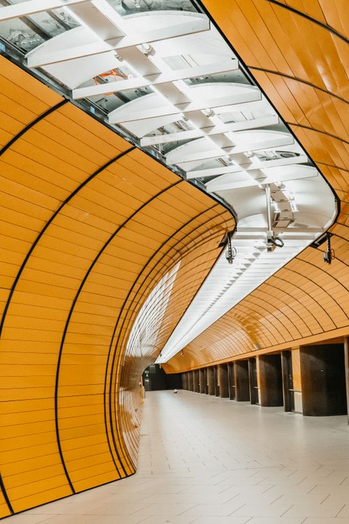 Free Explore the sleek design of a Munich metro station with its vibrant orange curving walls. Stock Photo