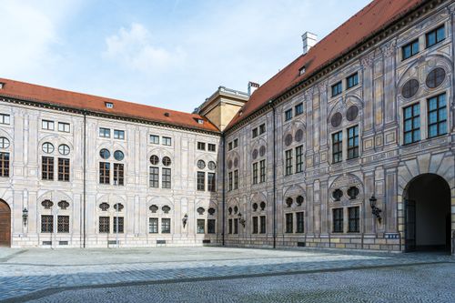 Free Elegant baroque architecture of a historical palace courtyard bathed in sunlight, showcasing intricate facade details. Stock Photo