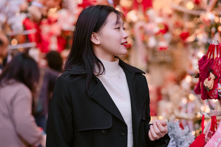 Young Woman In A Black Coat Over A White Sweater Doing Christmas Shopping