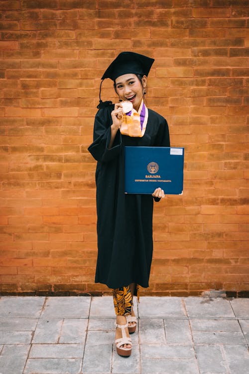 Woman Holding Medal While Standing Near Wall