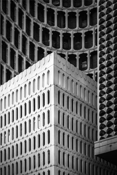 A black and white image showcasing a modern building's intricate facade and geometric patterns.