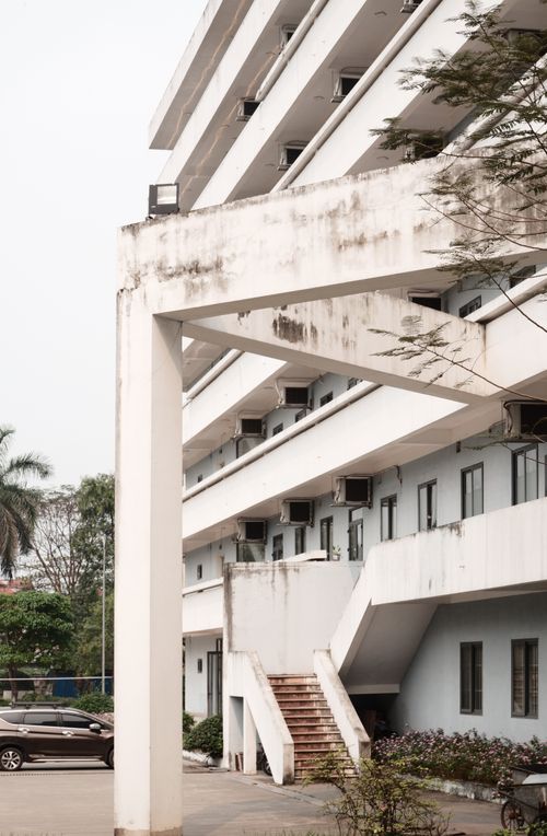 Free High-rise modern building exterior with balconies and parking lot in a minimalist style. Stock Photo