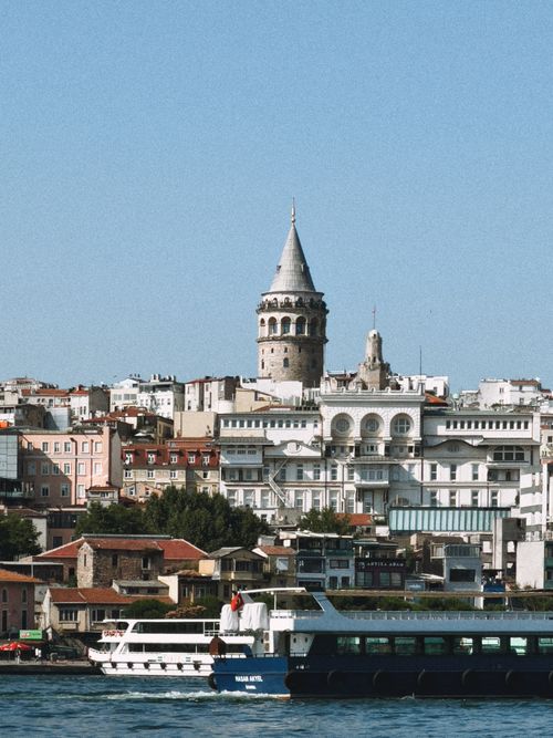 Free Scenic view of Galata Tower above Istanbul's harbor with ships on the water. Stock Photo
