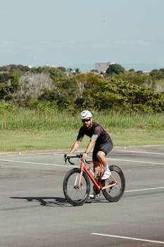 Adult male cyclist in helmet enjoying a ride on his bike in a sunny outdoor setting.