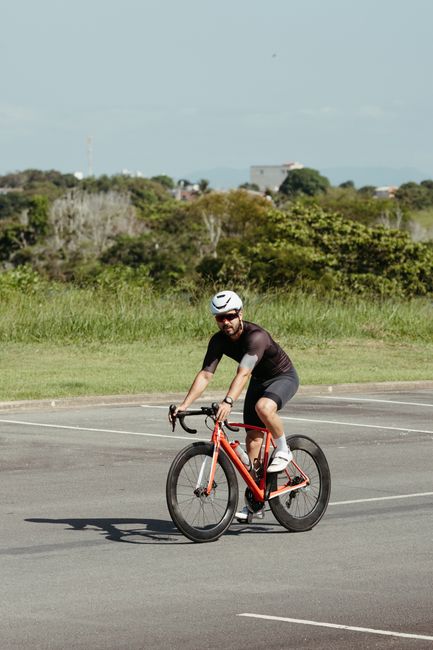 Adult male cyclist in helmet enjoying a ride on his bike in a sunny outdoor setting.