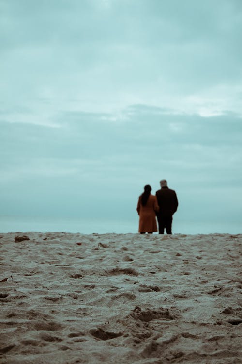 Sand on Beach and Couple Standing behind