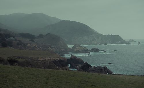 Free Misty view of rugged cliffs and coastal waves on a foggy day. Stock Photo