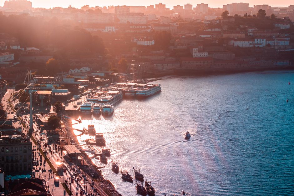 A stunning sunset over Porto's harbor, highlighting boats and the vibrant cityscape.