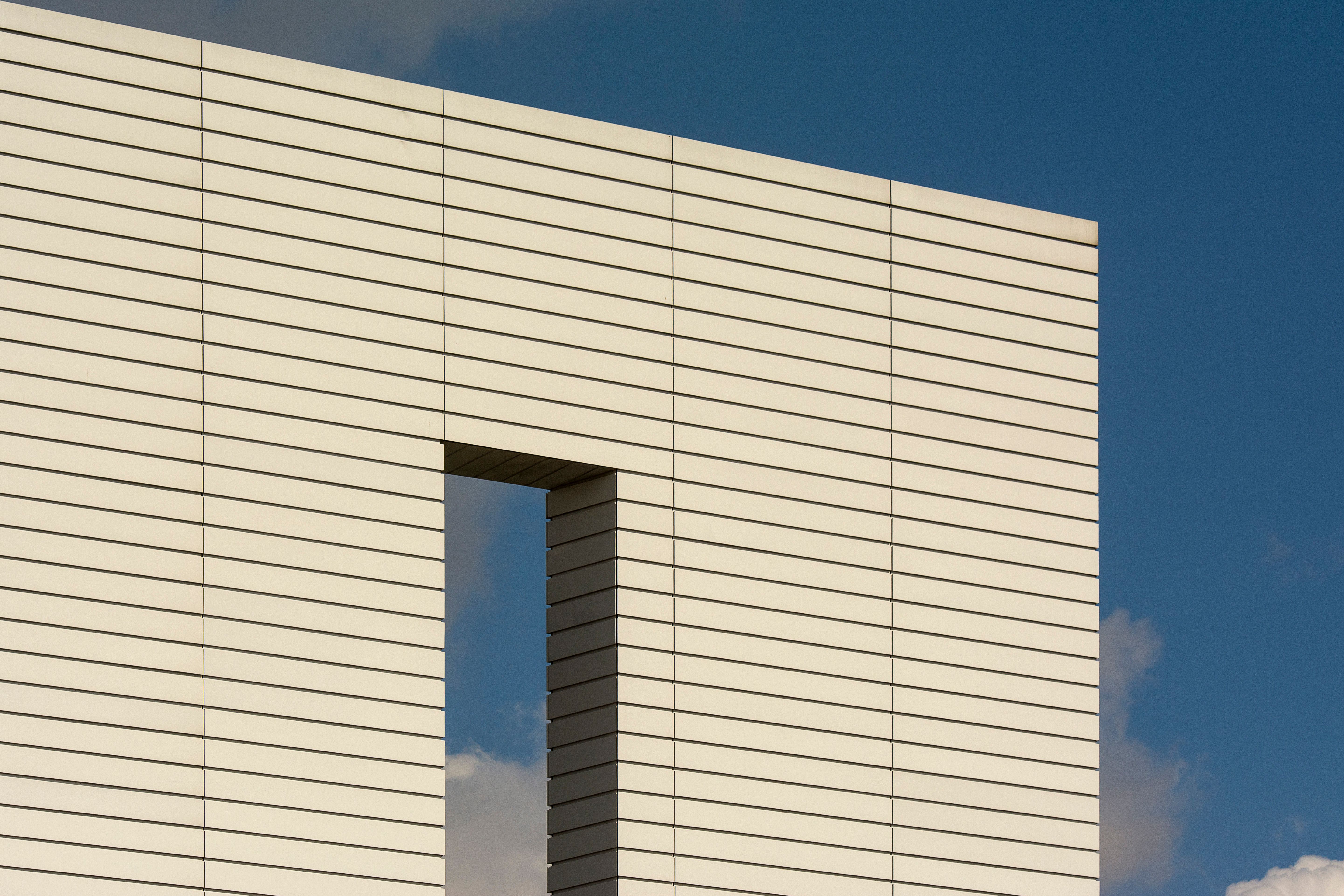 Modern Brick Building in Front of Blue Sky · Free Stock Photo