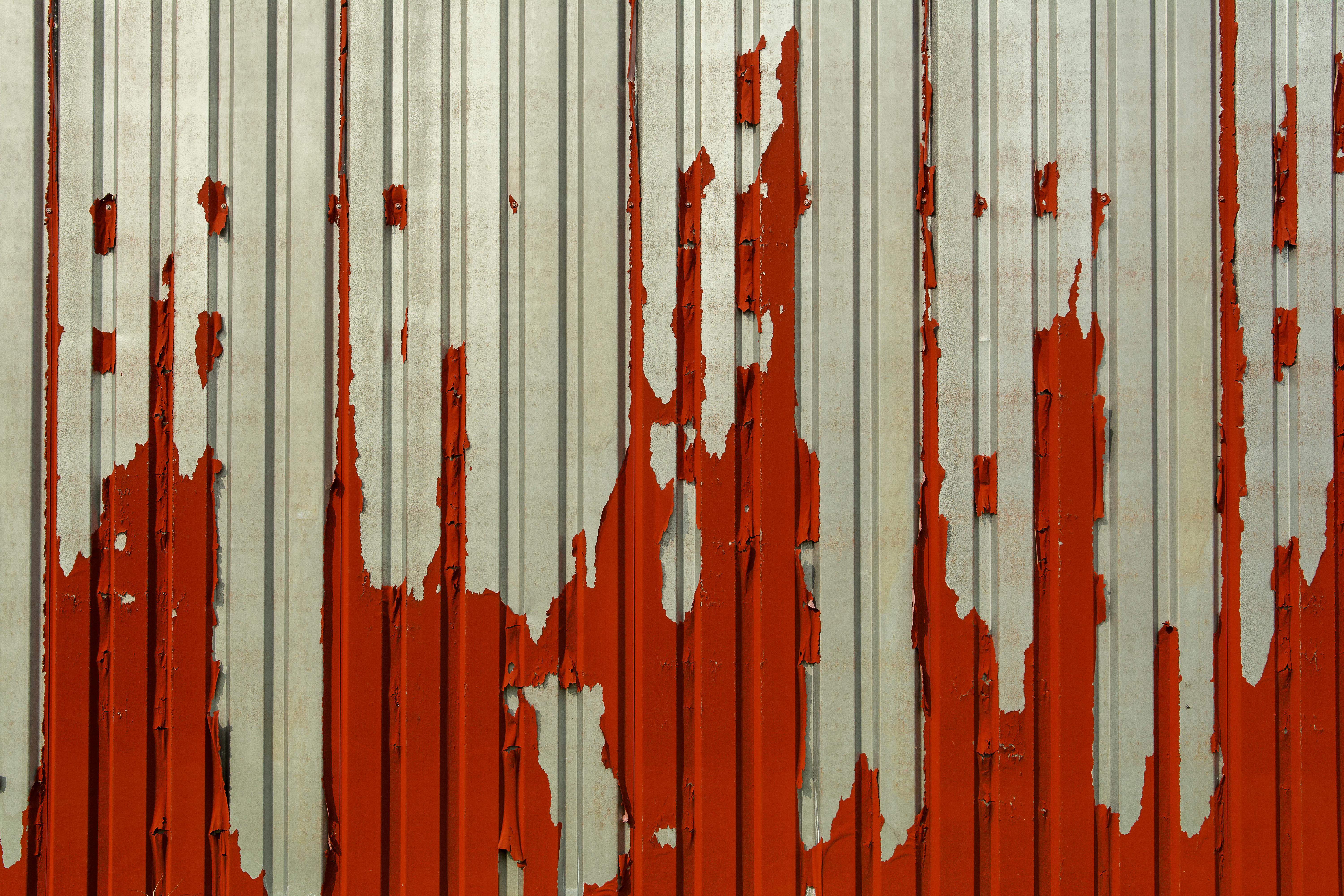 A red and white painted wall with rust by Jan van der Wolf