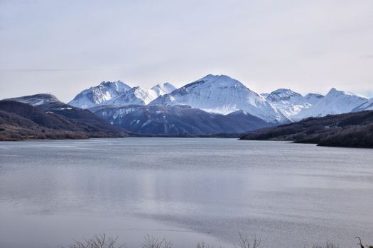 A lake with snow capped mountains in the background