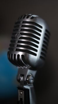 A detailed close-up of a vintage silver microphone, capturing its classic design and metal texture.