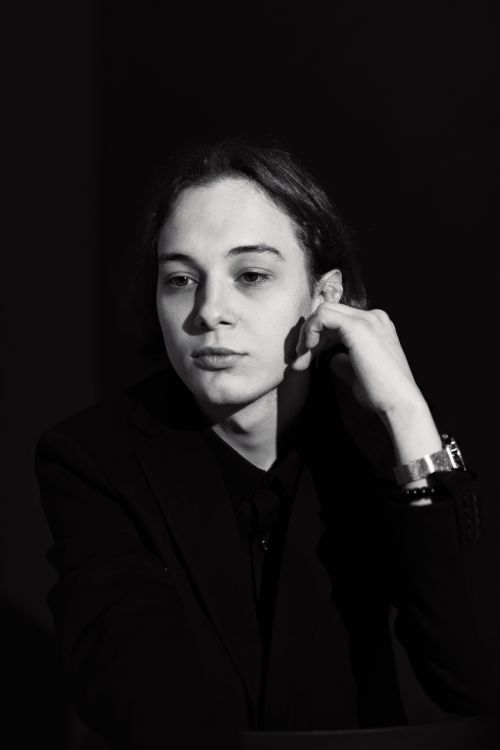 Free Stylish black and white portrait showcasing a pensive look, classic fashion sense, and subtle lighting. Stock Photo
