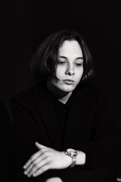 Free Elegant black and white portrait of a young adult in a blazer, capturing a moody fashion pose. Stock Photo